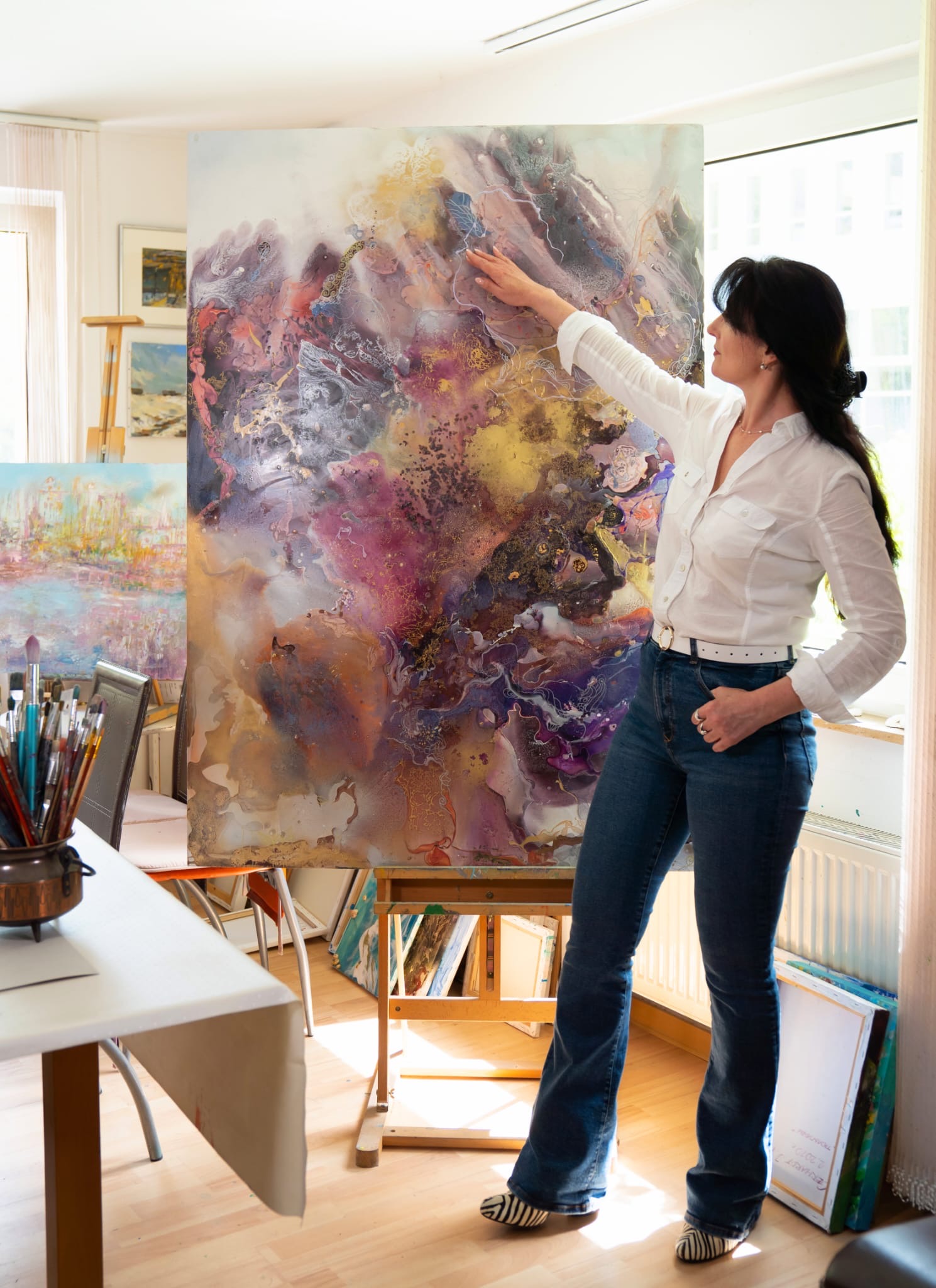 Irina Gerhardt in ihrem Atelier neben einer großformatigen abstrakten Arbeit